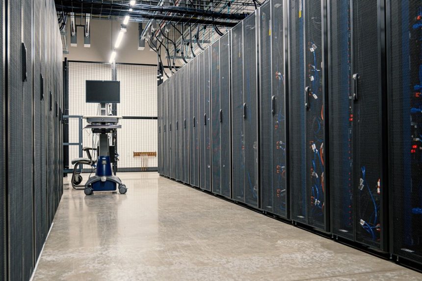 Armários metálicos com servidores, equipamentos de rede e cabos em um data center moderno.