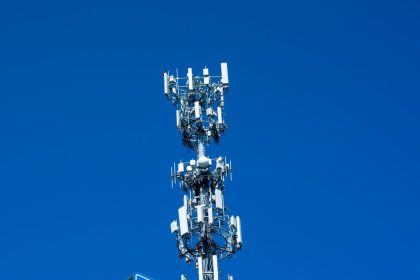 Torre de telecomunicações equipada com diversas antenas contra um céu azul claro