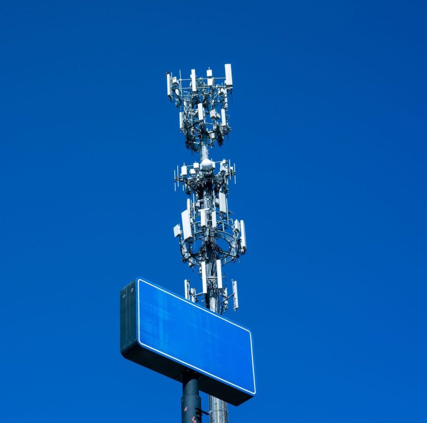 Torre de telecomunicações equipada com diversas antenas contra um céu azul claro